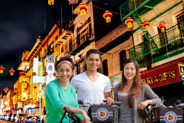 three people on rented bicycles in san francisco smile in chinatown