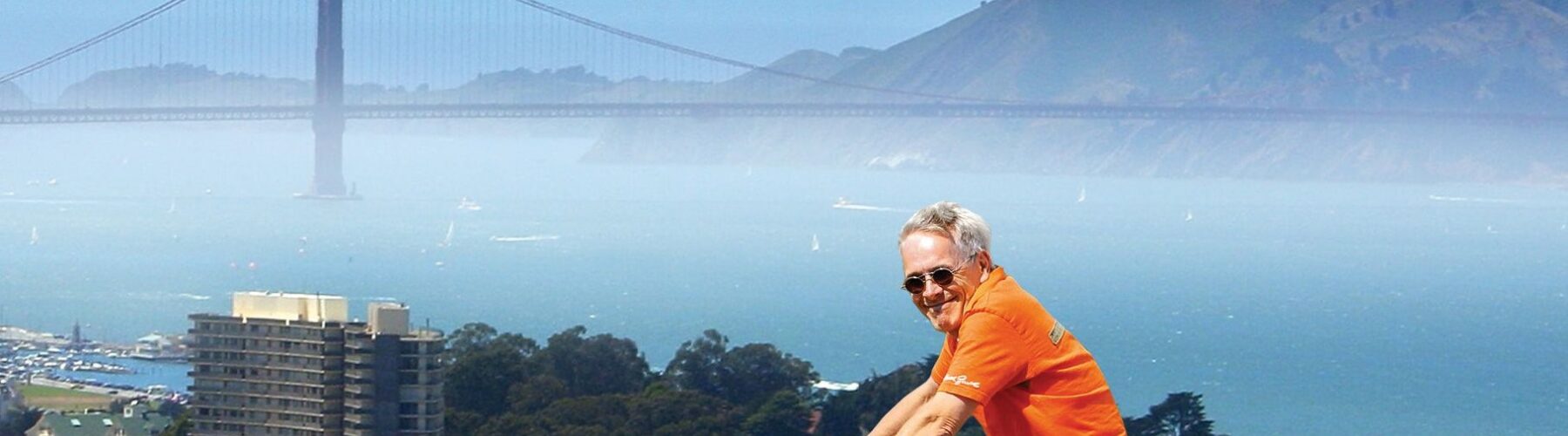 A man on a bike smiles while biking above San Francisco