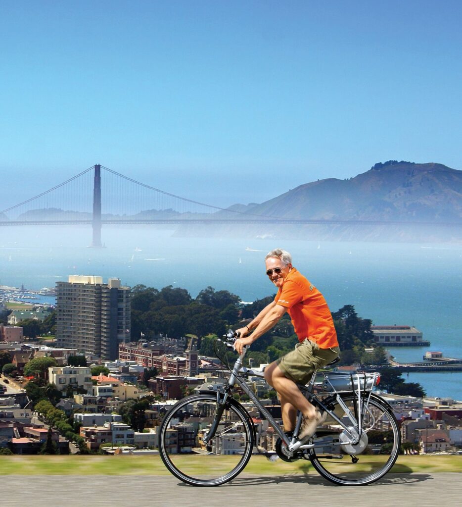 A man on a bike smiles while biking above San Francisco
