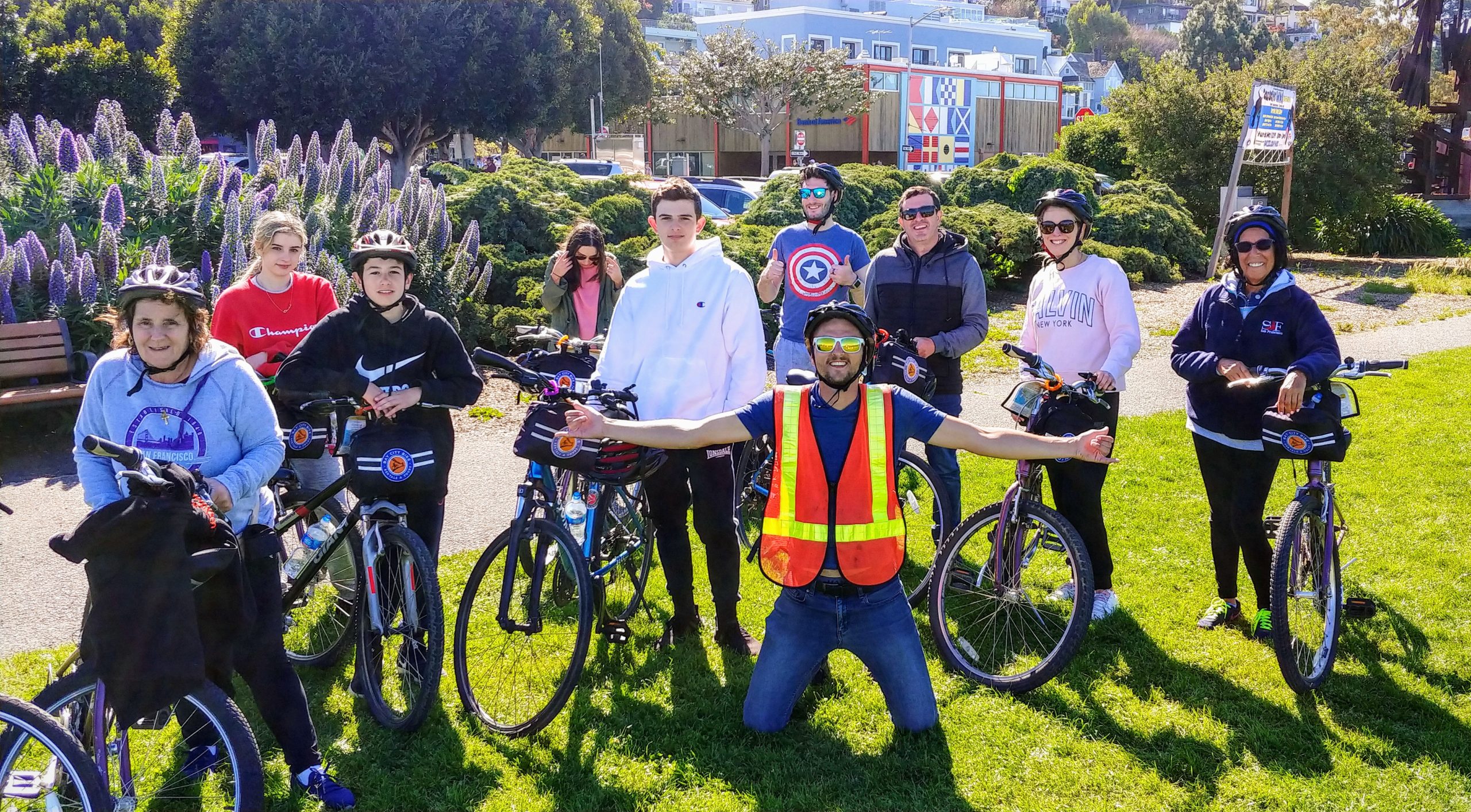 A group of people smile while holding their bikes during a Bay City Bike guided tour