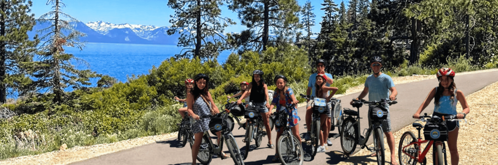 a family smiles while sitting on their bike rentals in lake tahoe during a long weekend trip