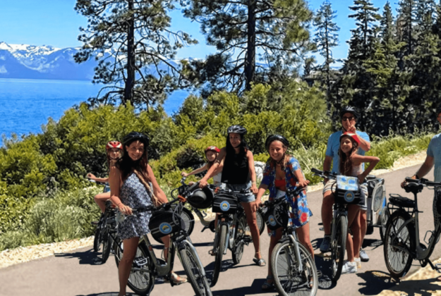 a family smiles while sitting on their bike rentals in lake tahoe during a long weekend trip